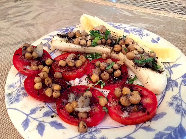 India-Food-Delhi-Breakfast-of-Kulia-Chat-with-sliced-tomatoes-baby-chickpeas-and-sliced-bananas This traditional South Delhi dish of Kulia Chat with sliced tomatoes baby chickpeas and sliced bananas is rarely prepared these days, but the tradition is being kept alive at Prakash Kutir Homestay