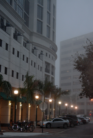 The main entrance to 100 Central on a foggy evening in downtown Sarasota
