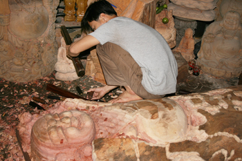 Wood carvers chip away at a giant Buddha