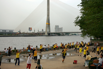 Aerobics in the park with the Rama VIII bridge in the background bangkok thailand