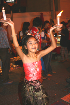 Tiny Thai girl performs dance with lighted candles in Chiang Mai