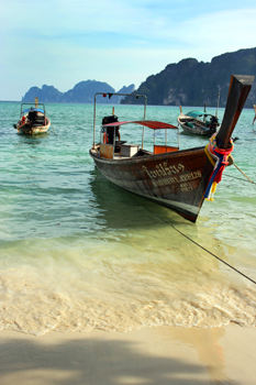 Long tail boats, turquoise water, and emerald seas stacks on Phi Phi Island Thaiand