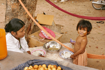 Happy Cambodian child wears his dinner as much as he eats it