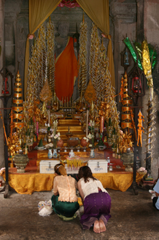 Thai women prostrate inside Angkor Wat temple ruins