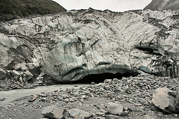 River flows from yawning mouth at foot of the Franz Josef glacier New Zealand