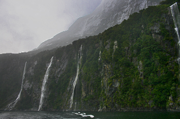 Hundreds of waterfalls emerge in the rain at Milford Sound New Zealand