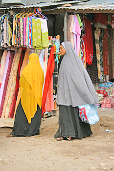 Muslim women examine luxurious bolts of cloth