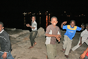 Kids at the waterfront in Stone Town Zanzibar dive off the wharf and play tag