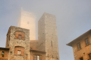 Towers of San Gimignano Italy are revealed one by one as morning mist buns off