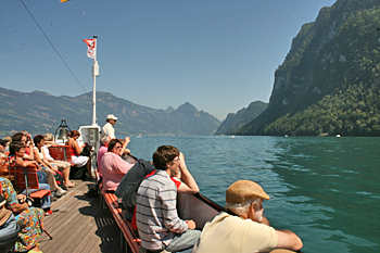 Sheer mountains rise from the blue green waters of Lake Lucerne Switzerland
