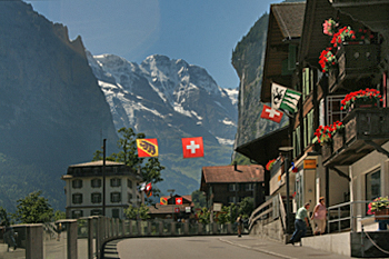 Staubbach Falls streams off high cliff at the end of Main Street in the village of Lauterbrunnen Switzerland
