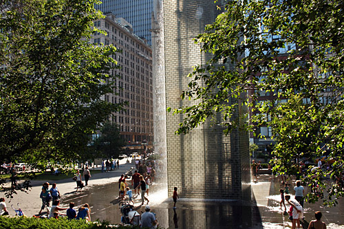 Children frolic in water cascading off the 50-foot glass towers that make up the Crown Fountain in Millennium Park