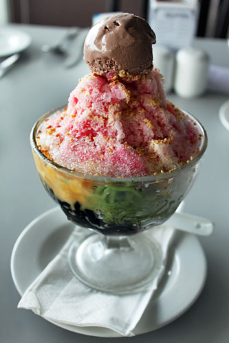 Iced Kacang, a traditional dessert of shaved ice with red beans, creamed corn, banana, colored jelly and syrup, topped with chocolate ice cream
