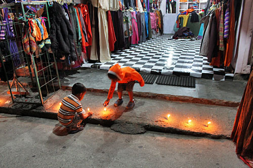 Candles burn on the stoops of stores and homes during Tihar, also known as the Festival of Lights