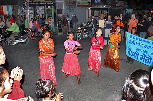 Dancers perform in the streets of Pokhara for donations on the third evening of the Tihar Festival