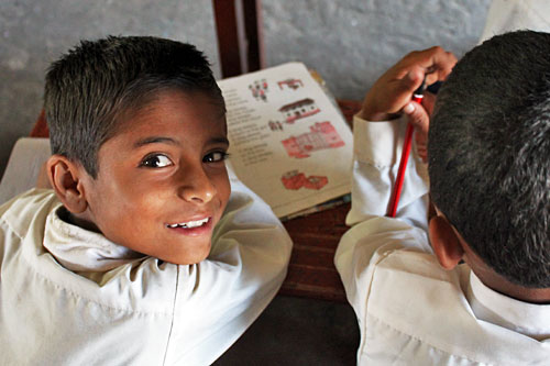 Kids study English manual at Annapurna School under the direction of Volunteer English teachers