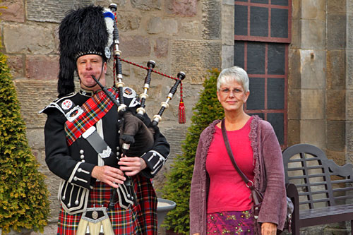 Me in a skirt, posing next to a Scottish bagpiper at the entrance to "Taste of Scotland" 