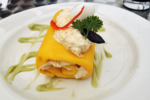 Peruvian Causa: Mashed yellow potato dumpling molded around crab on a bed of avocado sauce, topped with a Quail egg