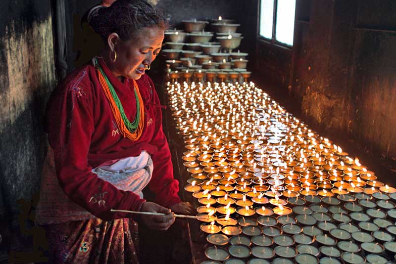Tamang Woman Lights Butter Candles to Pray for Her Ancestors at Swayambhu Temple in Kathmandu, Nepal