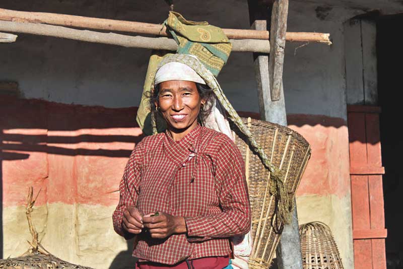 Gurung Woman Straps a Basket to Her Forehead to Carry Food in Pumagaon, Nepal