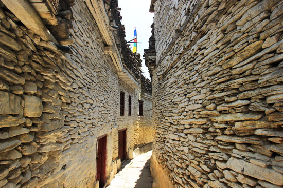 Piles of split wood are piled on the flat roofs of the old stone houses of Marpha in the Himalayan Mountains of Nepal