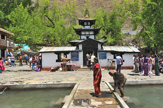 Fully clothed worshipers immerse in the freezing cold holy pools in front of Muktinath, one of the eight most sacred Hindu shrines in the world