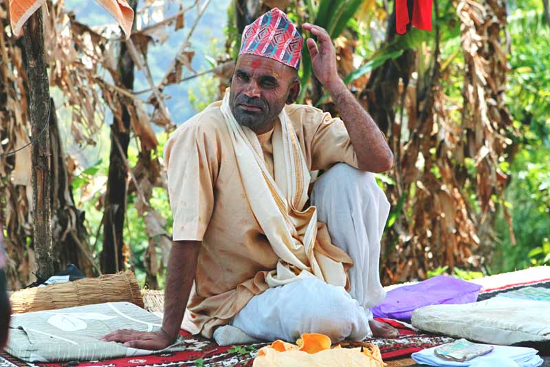 Priest Relaxes at a Puja for a Deceased Family Member in Nayagaon, Nepal