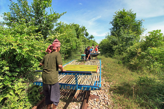 Breaking down car to let oncoming traffic pass on Bamboo Train near Battambang, Cambodia