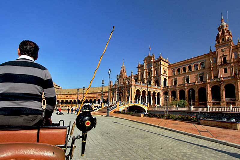Horse-drawn Carriage Carries Tourists Past Plaza de Espana in Seville, Spain
