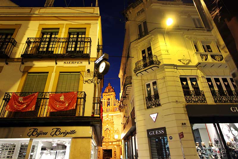 Church Peeks Through Buildings, a Typical Night Street Scene in Seville, Spain