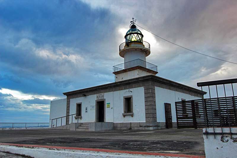 Sun Breaks Through Threatening Clouds, Illuminating Lens of Cap de Creus Lighthouse in Catalonia, Spain