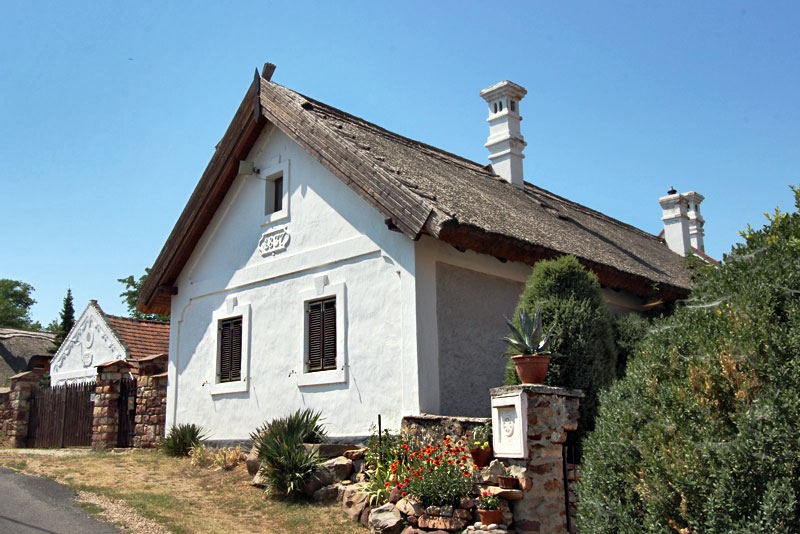 Hungarian Peasant Old Stone Cottage in the Kali Basin Features Thatched Roof, Whitewashed Walls, and Carved Plaster