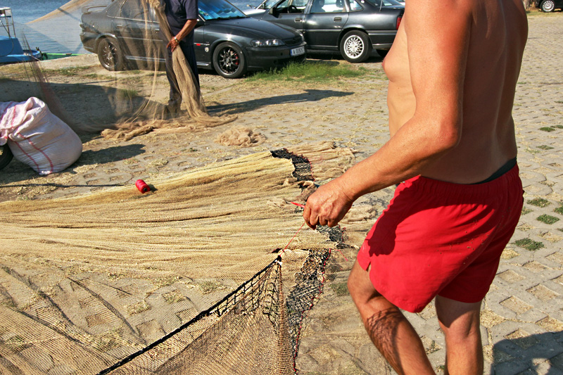 Mending Fishing Nets by Hand on the Wharf Along the Black Sea in Sozopol, Bulgaria