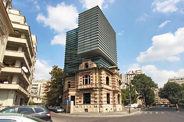 Remaining front of 19th Century Grigore Paucescu building near Revolution Square, with modern building built behind it, still shows bullet holes from 1989 uprising