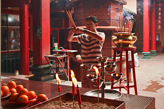 Making offerings at the Guan Di Buddhist Temple in Chinatown, Kuala Lumpur