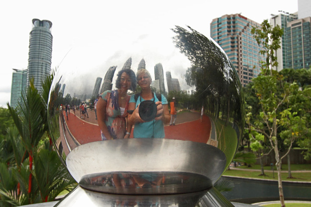 Selfie in a silver reflecting globe with Juno Kim of RunawayJuno.com at Kuala Lumpur Petronas Towers