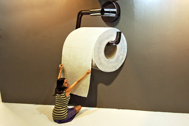 Paola is dwarfed by this giant roll of toilet paper...
