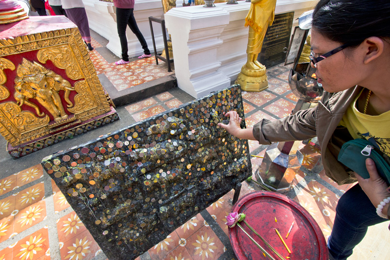 Buddhists Earn Merit by Pressing Coins Onto Panel at Doi Suthep Temple in Chiang Mai, Thailand