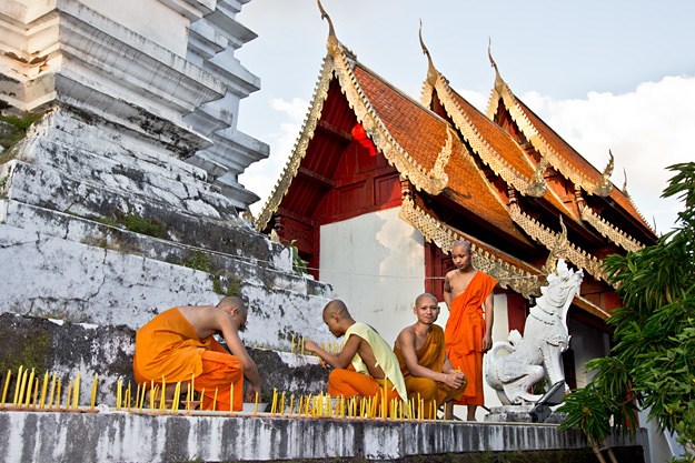 Monks at Wat Muentoom decorate the chedi with candles that will be lit after dark in celebration of Yi Peng