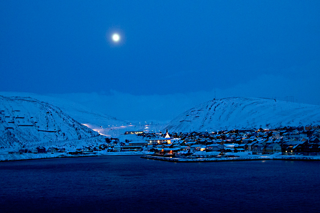 Moon rises over Kjollefjord Norway where fishermen pull 40 tons of King Crab from the fjord every day