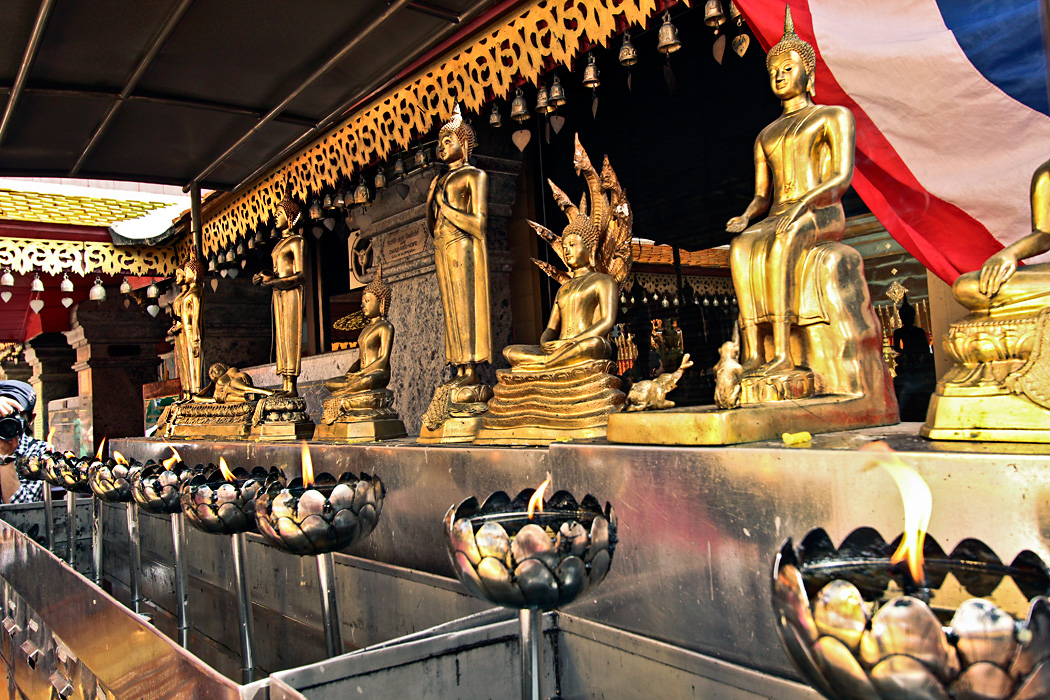 Flames Stand Sentinel Before an Array of Buddhas at Doi Suthep Temple in Chiang Mai, ThailandThailand-Chiang-Mai-Doi-Suthep-Temple-Buddhas