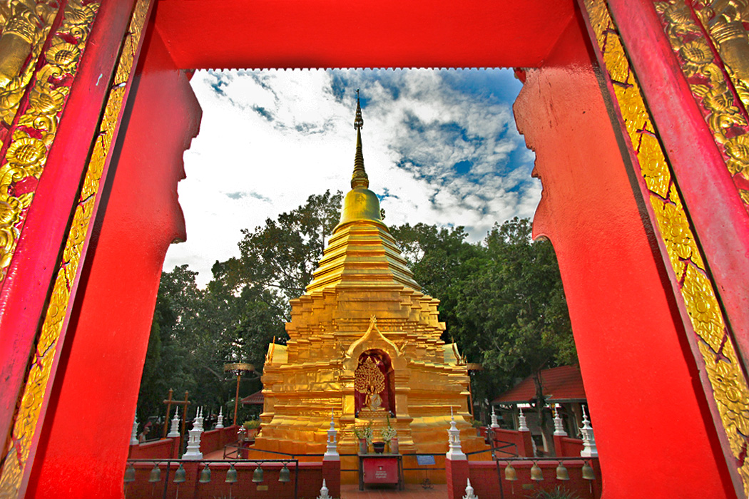Golden Chedi at Wat Phan On in Chiang Mai, Thailand, seen through the window of the prayer hall