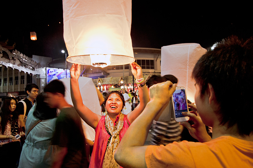 Young couple launch paper lantern at Yi Peng Festival in Chiang Mai, Thaland 
