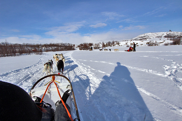 Speeding down the wide open expanse of a frozen lake in Kirkenes, Norway