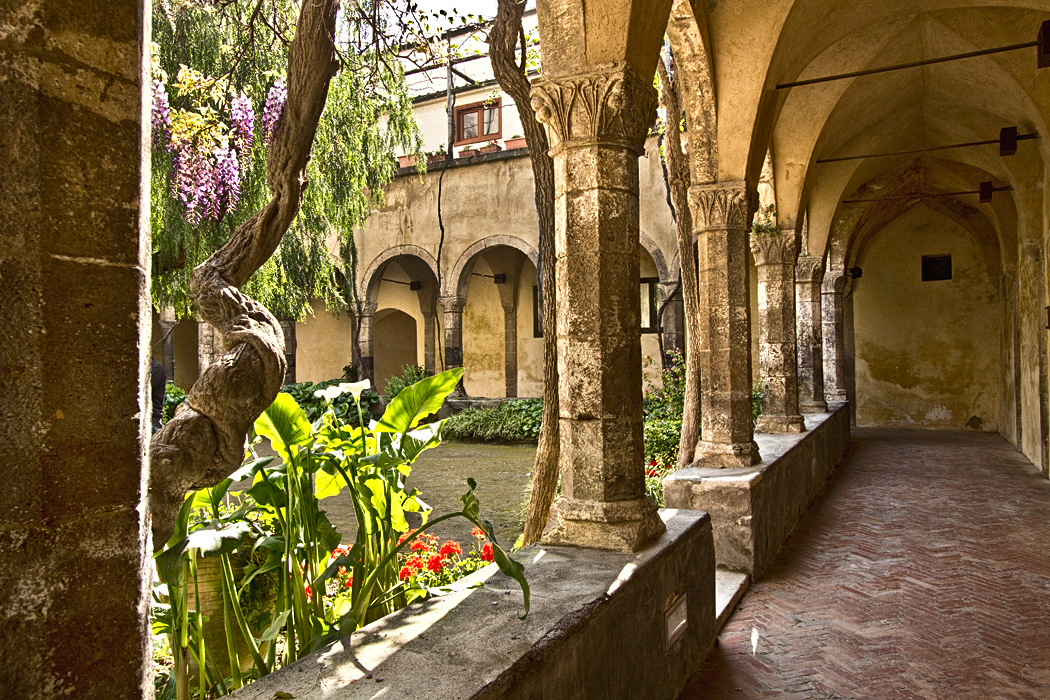 Gothic columns surround a peaceful garden at the Cloister of St. Francis in Sorrento, Italy