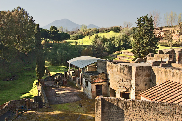 More ruins lie beneath gently rolling hills that stretch to the horizon, where a deceptively peaceful Mount Vesuvius looms