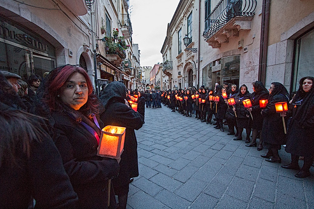 Good Friday participants walk down Corso Umberto in two silent files