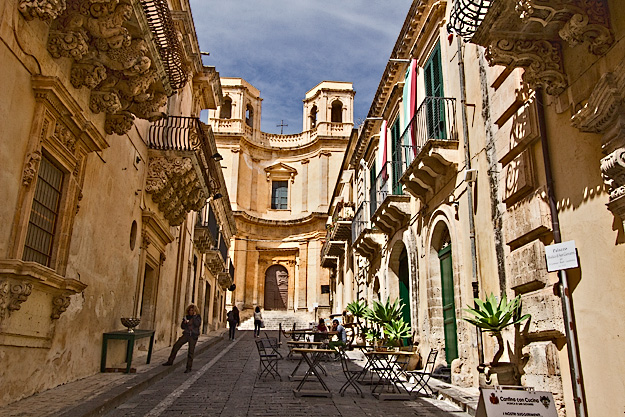 View up Via Nicolaci with sun-splashed Montevergini Church at the top of the lane