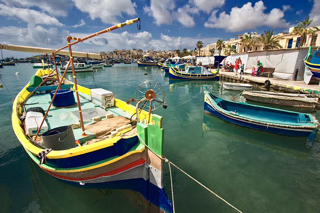 Fishing boats in the harbor at Marsaxlokk , Malta are painted in rainbow colors