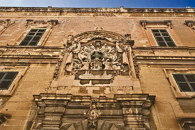Coat of arms on Auberge D'Italie, one of many palaces in Valletta, Malta, tells a story of war